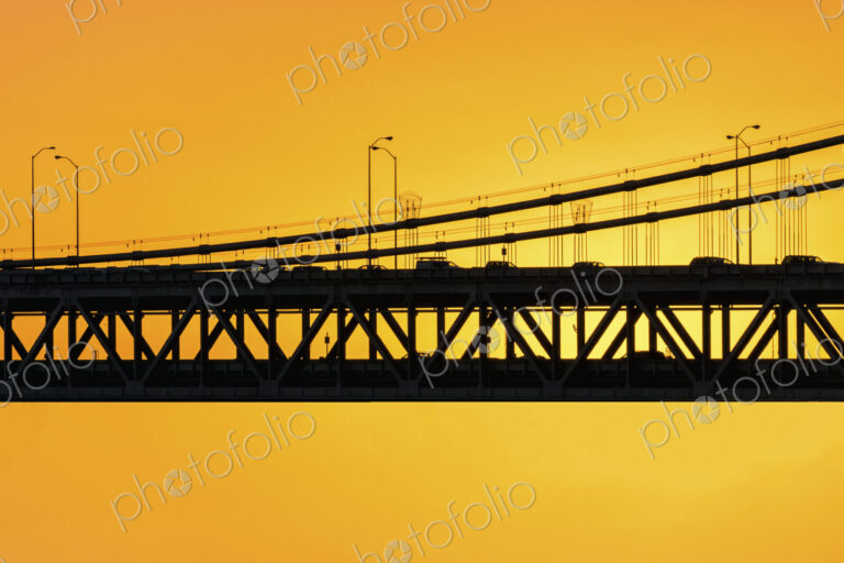 The Bay Bridge silhouetted against a sunset sky