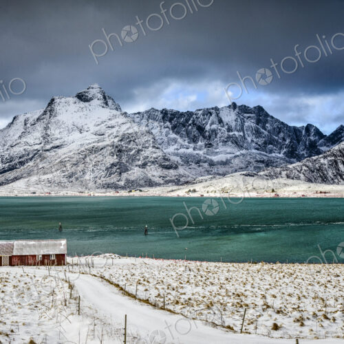 The Lofoten islands in snow, turquoise green water, small fishing village and houses…