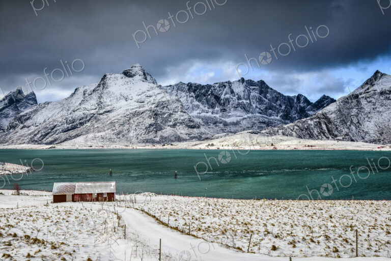 The Lofoten islands in snow, turquoise green water, small fishing village and houses…