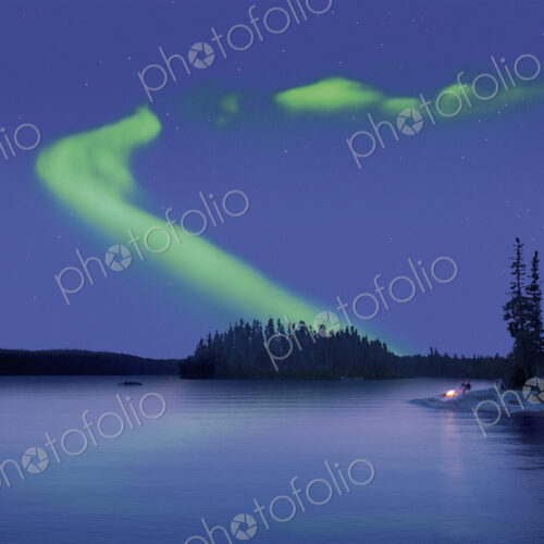 The Northern Lights in the night sky, the Aurora borealis above a calm lake. Two…