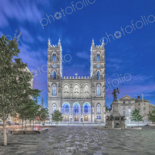 The Notre Dame Basilica, lit up at dusk in the city square in the Old Town of Montreal. The Notre Dame Basilica, lit up at dusk in the city square in the Old Town of Montreal.