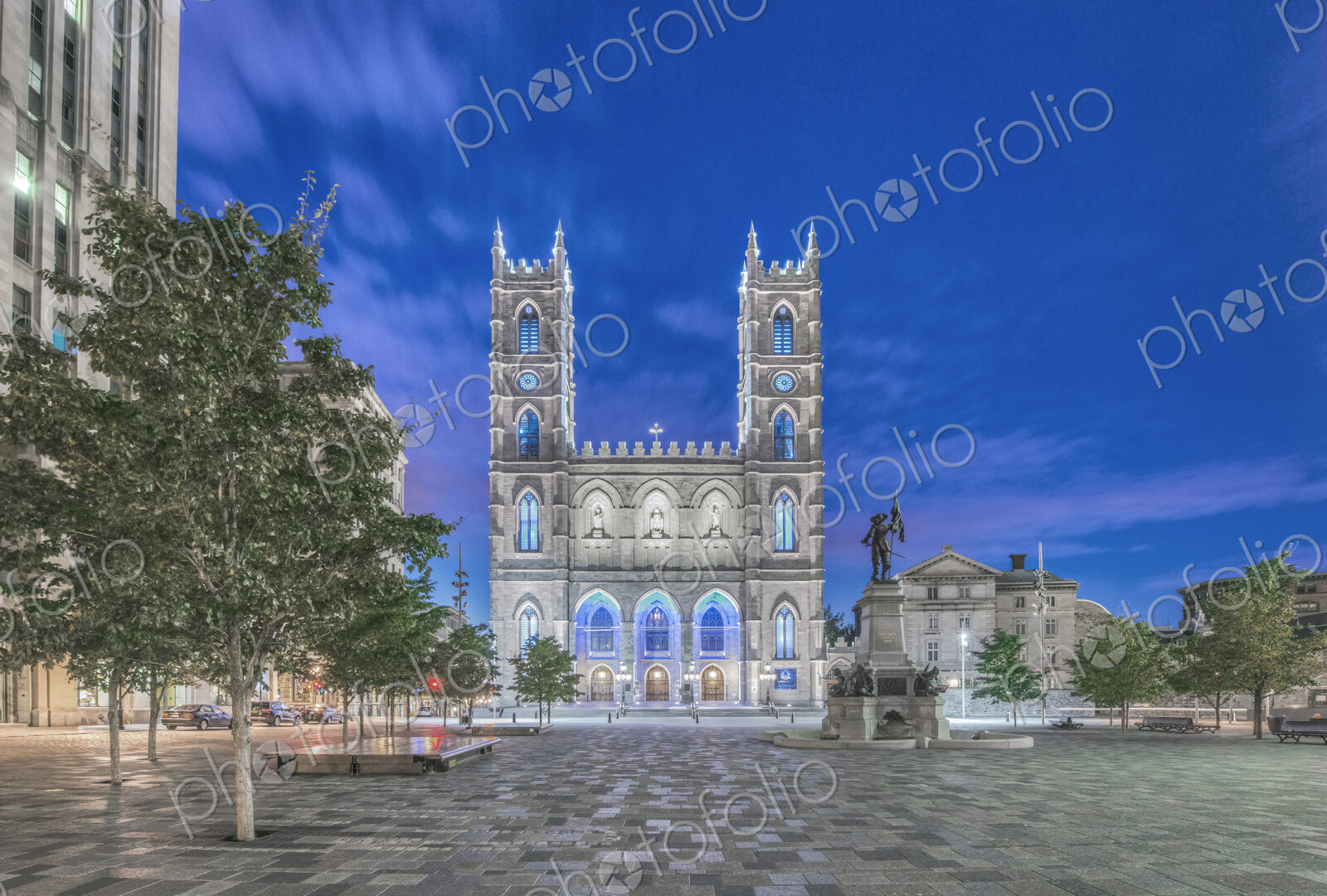 The Notre Dame Basilica, lit up at dusk in the city square in the Old Town of Montreal.