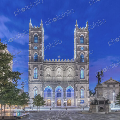 The Notre Dame Basilica, lit up at dusk in the city square in the Old Town of Montreal. The Notre Dame Basilica, lit up at dusk in the city square in the Old Town of Montreal.