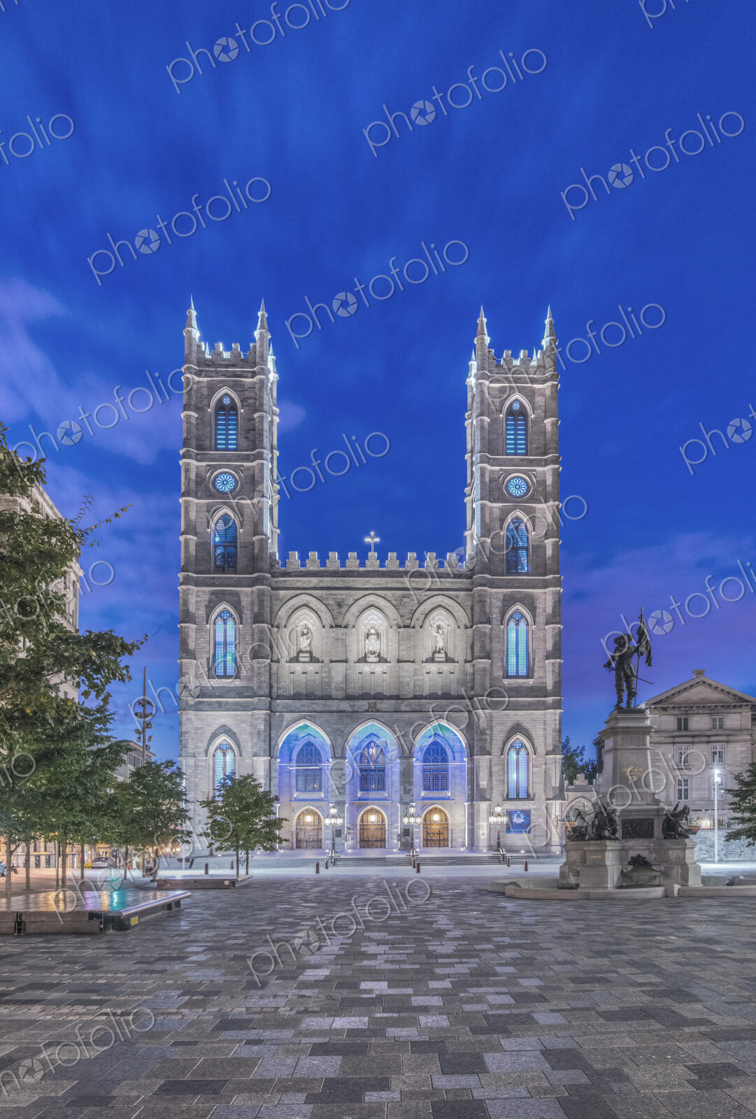 The Notre Dame Basilica, lit up at dusk in the city square in the Old Town of Montreal.