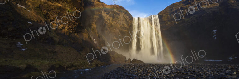 The Skagafoss waterfall, a tall cascade over a sheer cliff, mist and a Double Rainbow…