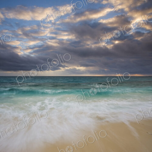 The beach and the water's edge. A cloudy sky. The beach and the water's edge. A cloudy sky.