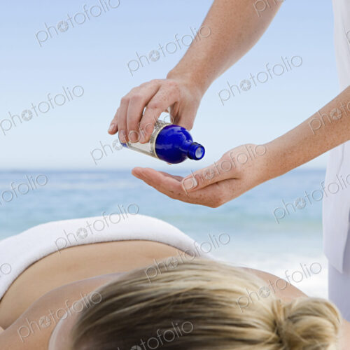 The beach. A young woman having a massage.