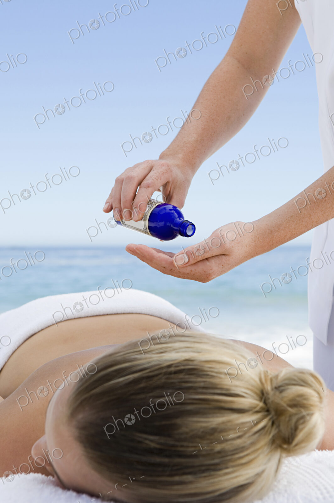 The beach. A young woman having a massage.