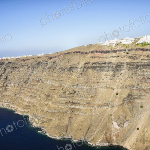The cliffs and rock formations of an island in the Aegean sea, with a town of… The cliffs and rock formations of an island in the Aegean sea, with a town of…