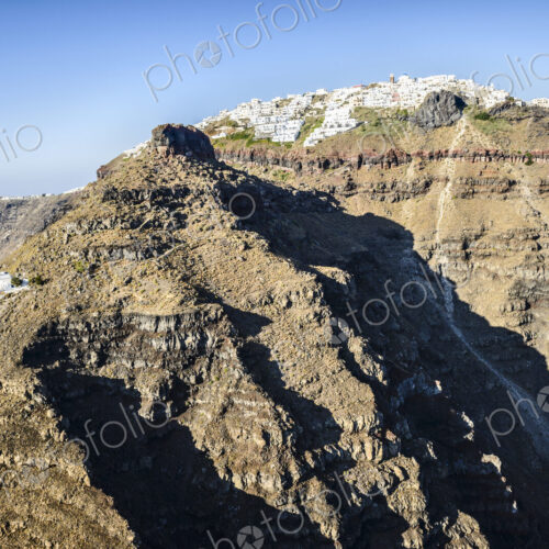 The cliffs and rock formations of an island in the Aegean sea, with a town of… The cliffs and rock formations of an island in the Aegean sea, with a town of…