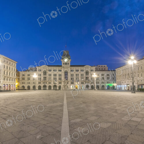 The empty piazza of Unity of Italy square, historic buildings and street lights.
