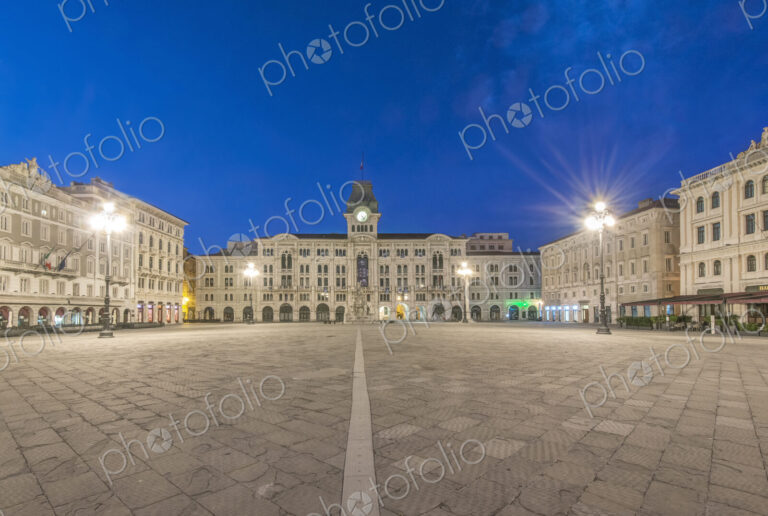 The empty piazza of Unity of Italy square, historic buildings and street lights.