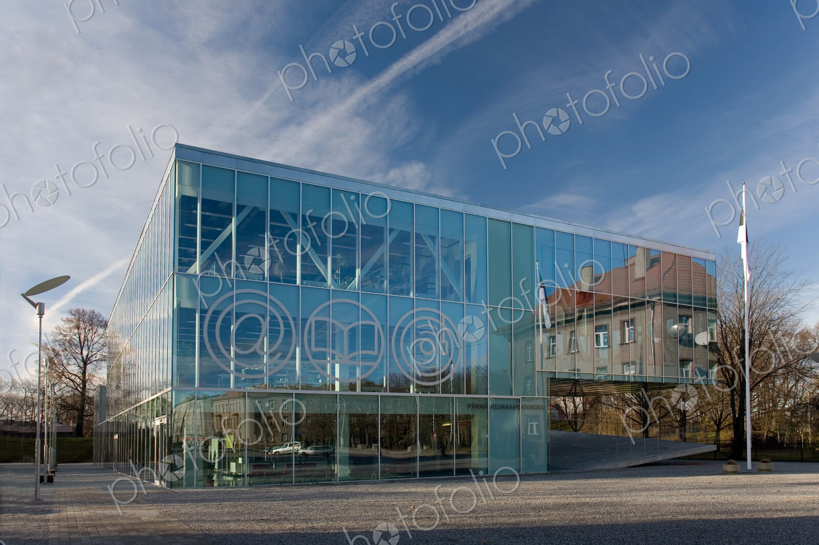 The exterior glass walls of a modern library building, internet icons etched on glass