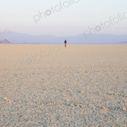 The figure of a man in the empty desert landscape of Black Rock desert, Nevada.
