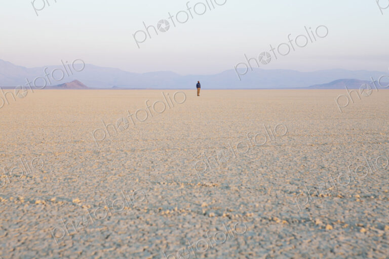 The figure of a man in the empty desert landscape of Black Rock desert, Nevada.