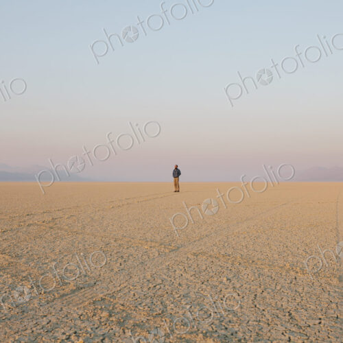 The figure of a man in the empty desert landscape of Black Rock desert, Nevada.