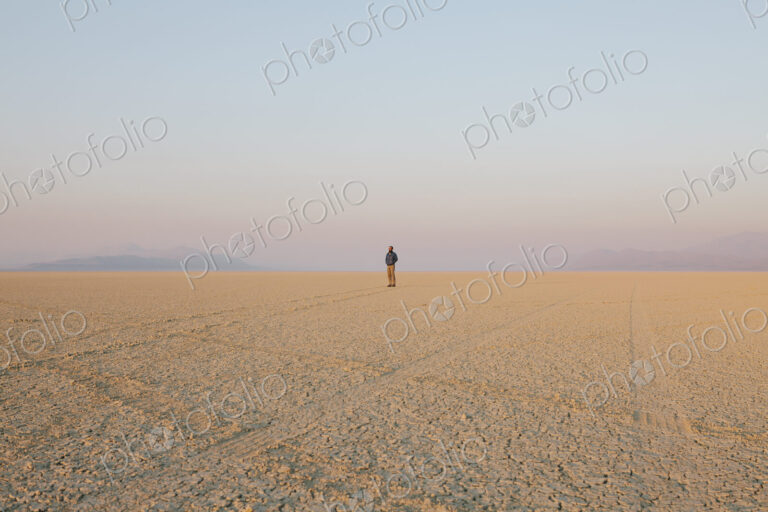 The figure of a man in the empty desert landscape of Black Rock desert, Nevada.