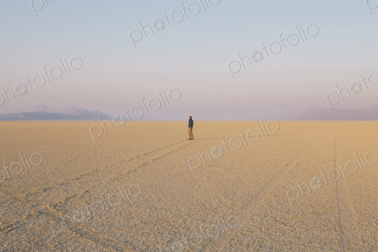 The figure of a man in the empty desert landscape of Black Rock desert, Nevada.