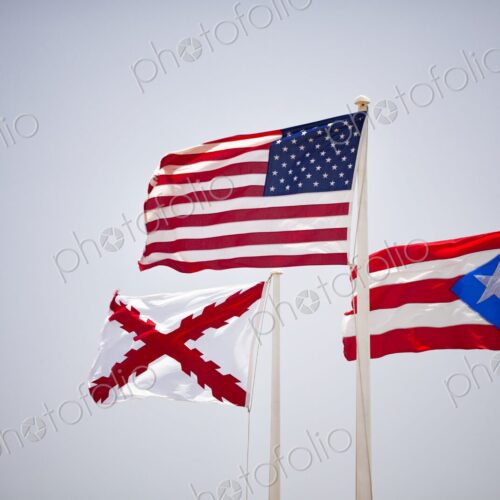 The flags of the United States, Puerto Rico, and the historic Cross of Burgundy wave… The flags of the United States, Puerto Rico, and the historic Cross of Burgundy wave…