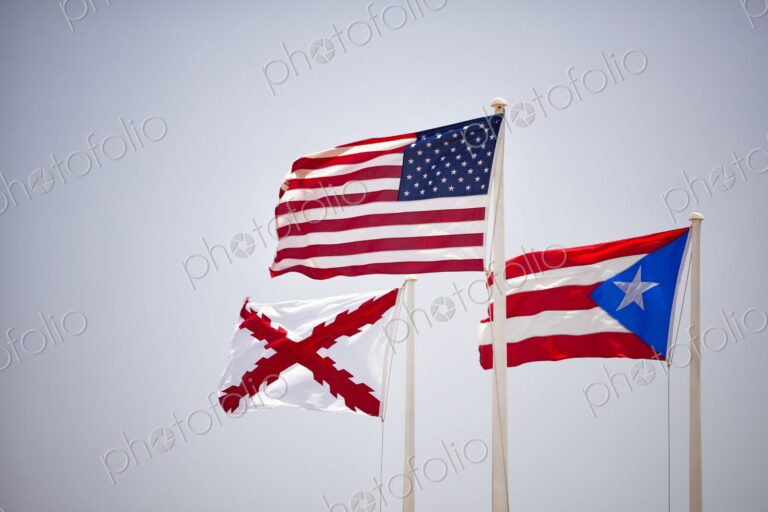 The flags of the United States, Puerto Rico, and the historic Cross of Burgundy wave…
