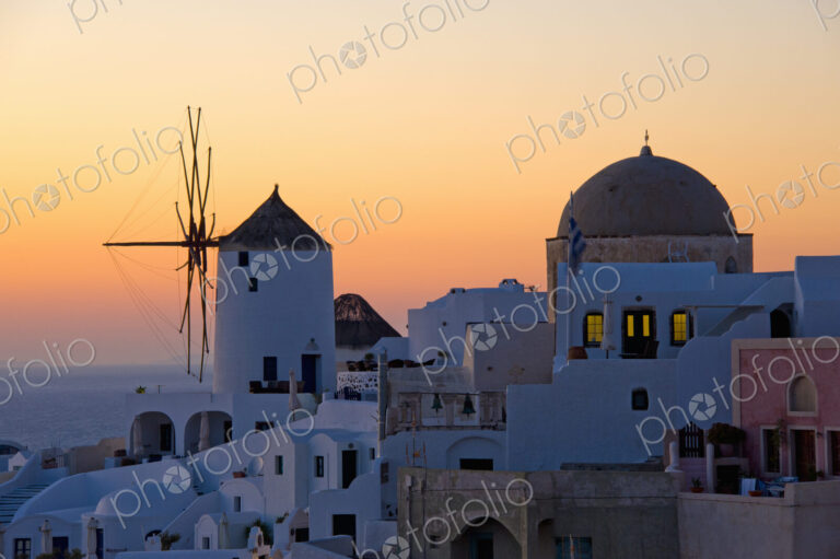 The historic white washed houses, windmills and domed church of Oia town on Santorini…