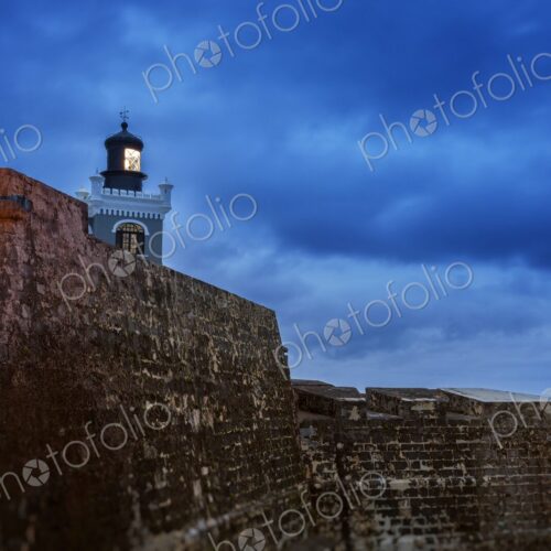 The iconic lighthouse of Castillo San Felipe del Morro glows at twilight above the… The iconic lighthouse of Castillo San Felipe del Morro glows at twilight above the…
