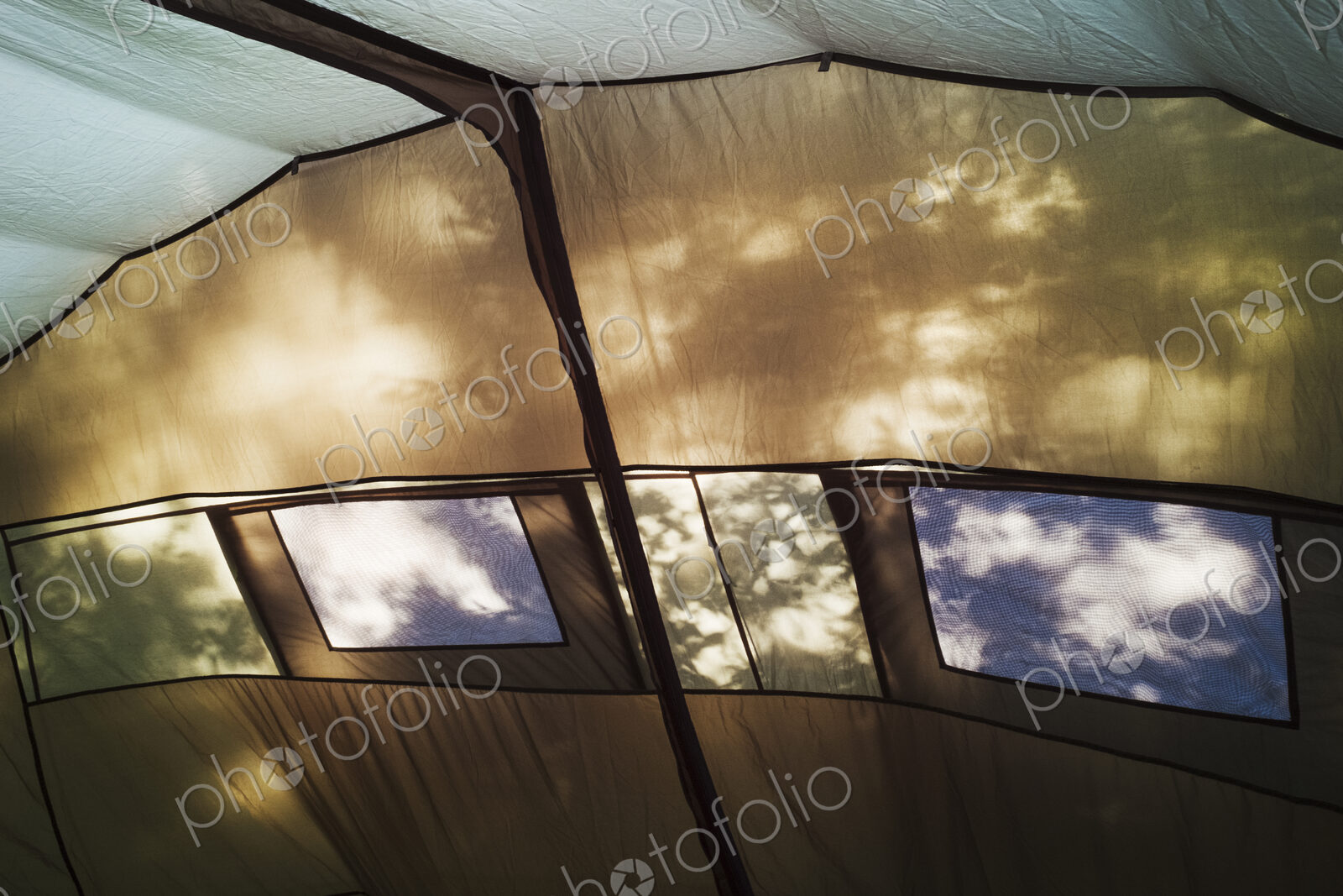 The interior of a large tent, roof and walls, windows and interior framework. Sunlight…