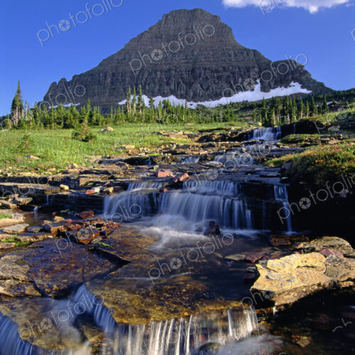 The landscape of Glacier National Park, to Mount Reynolds peak, and Logan Pass. Water… The landscape of Glacier National Park, to Mount Reynolds peak, and Logan Pass. Water…
