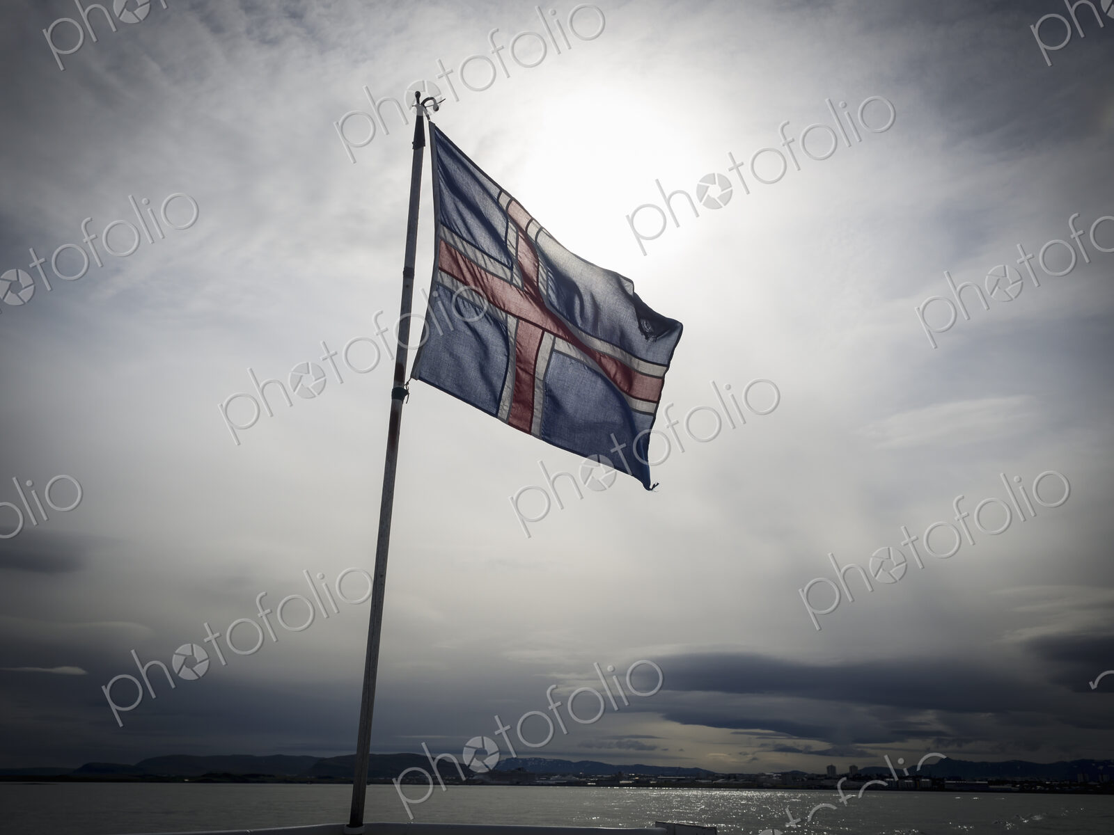 The national flag of Iceland, flying against a cloudy sky