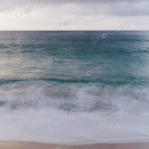 The ocean viewed from the beach, waves breaking on the beach and overcast sky. The ocean viewed from the beach, waves breaking on the beach and overcast sky.
