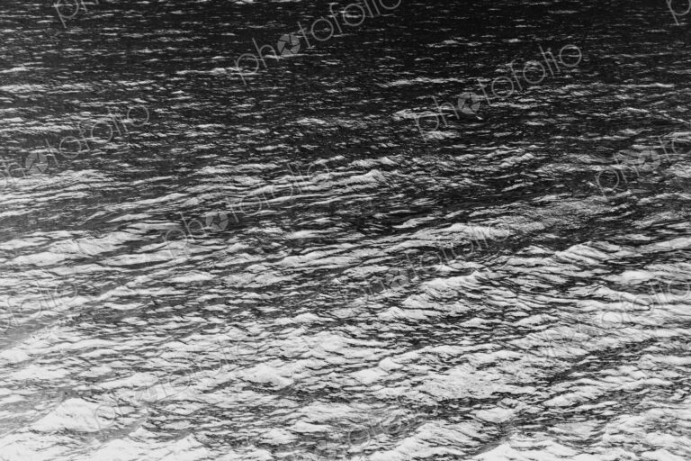 The ocean, water and waves, view of the water surface, in black and white.
