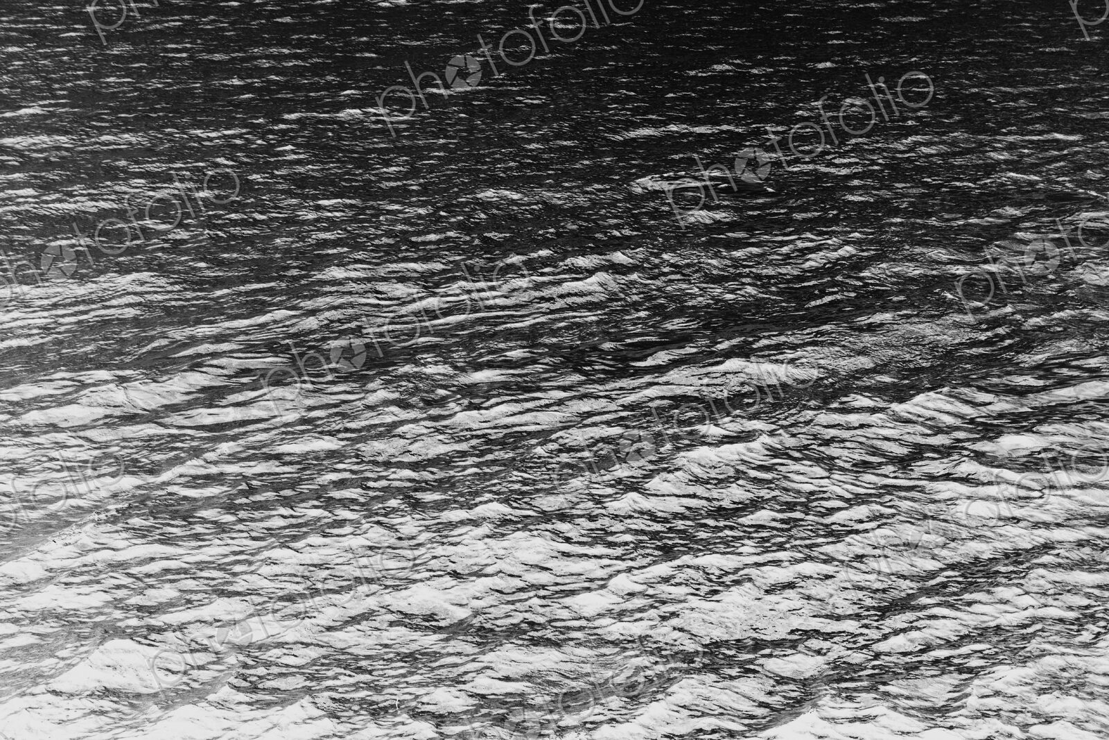 The ocean, water and waves, view of the water surface, in black and white.
