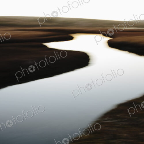 The open spaces of marshland and water channels. Flat calm water.