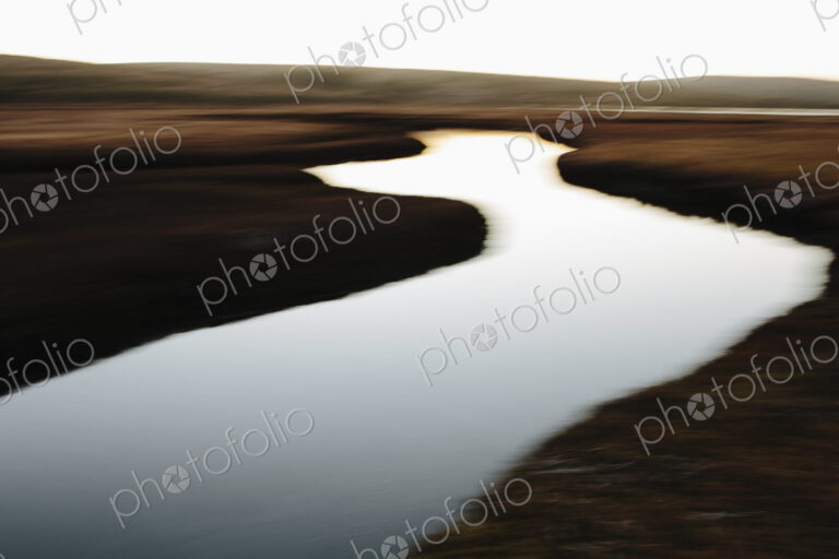 The open spaces of marshland and water channels. Flat calm water.