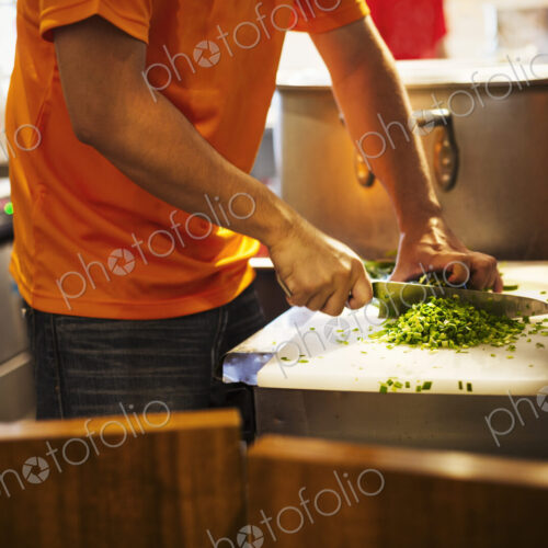 The ramen noodle shop. A chef chopping vegetables.