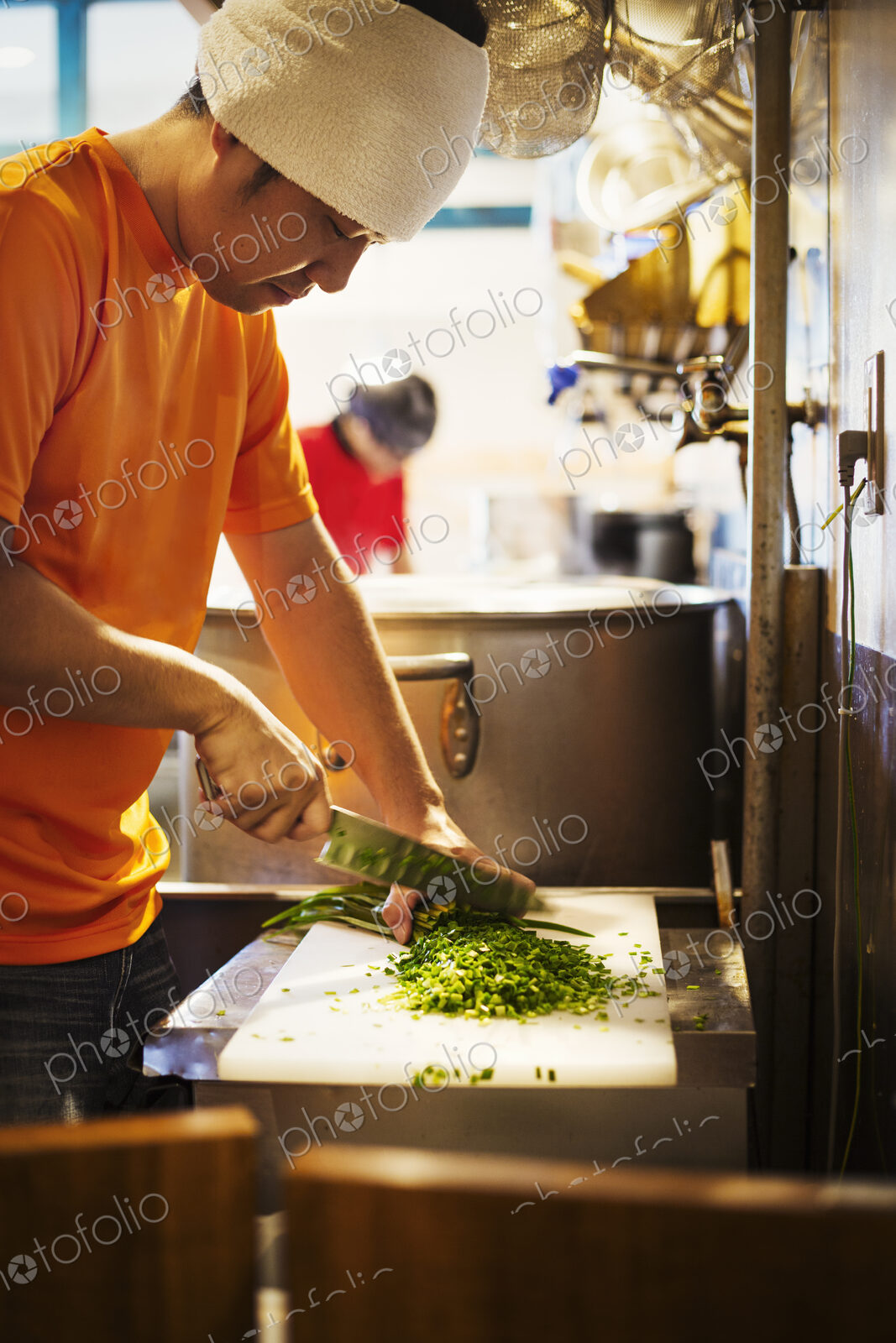 The ramen noodle shop. A chef chopping vegetables.