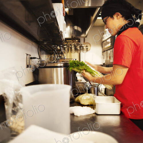 The ramen noodle shop. A chef working in a kitchen preparing food using a stove and…