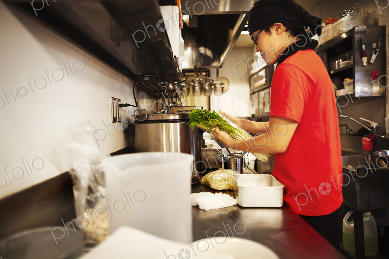 The ramen noodle shop. A chef working in a kitchen preparing food using a stove and…