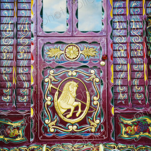 The rear of a traditionally decorated and painted gypsy caravan, door and windows.