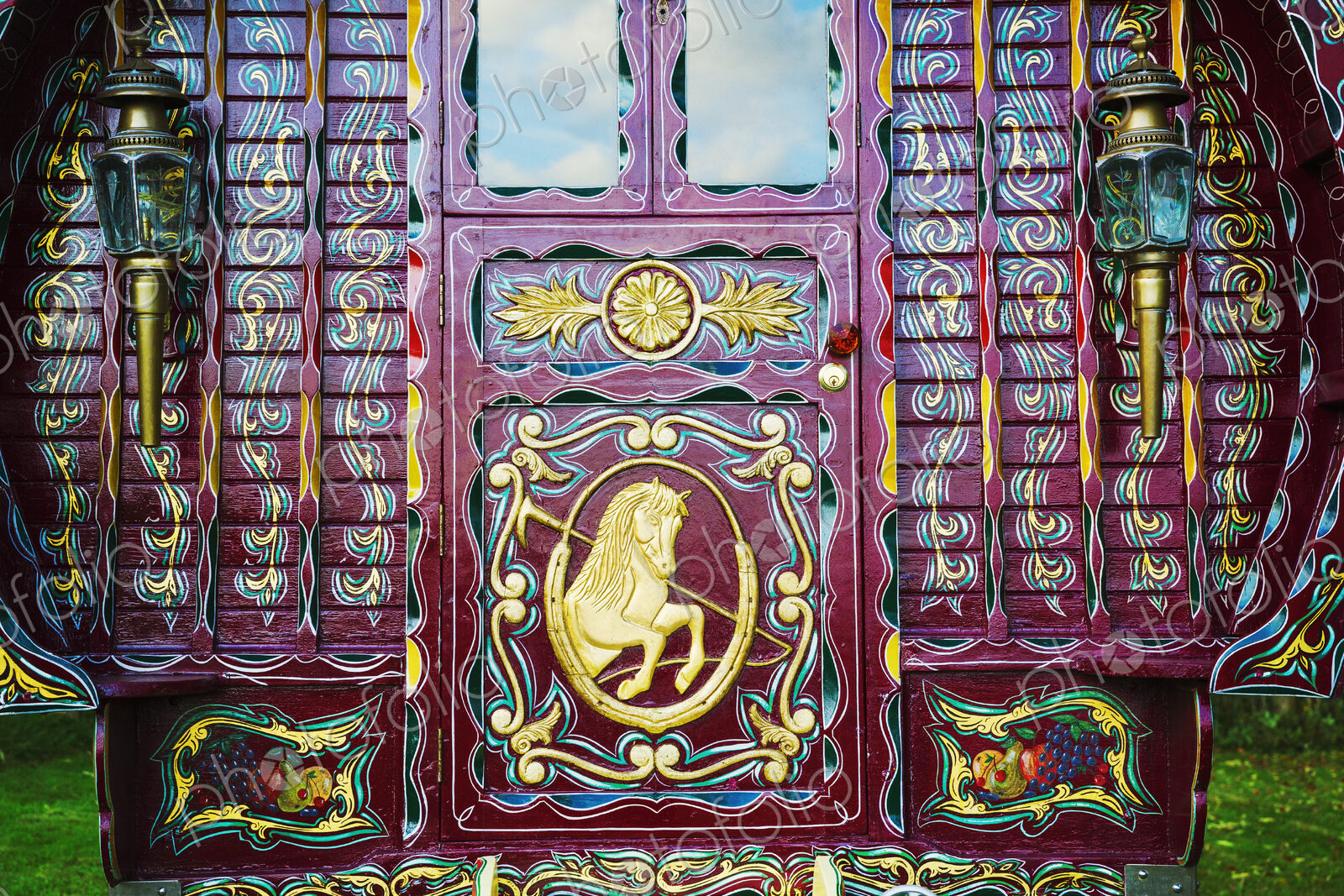 The rear of a traditionally decorated and painted gypsy caravan, door and windows.