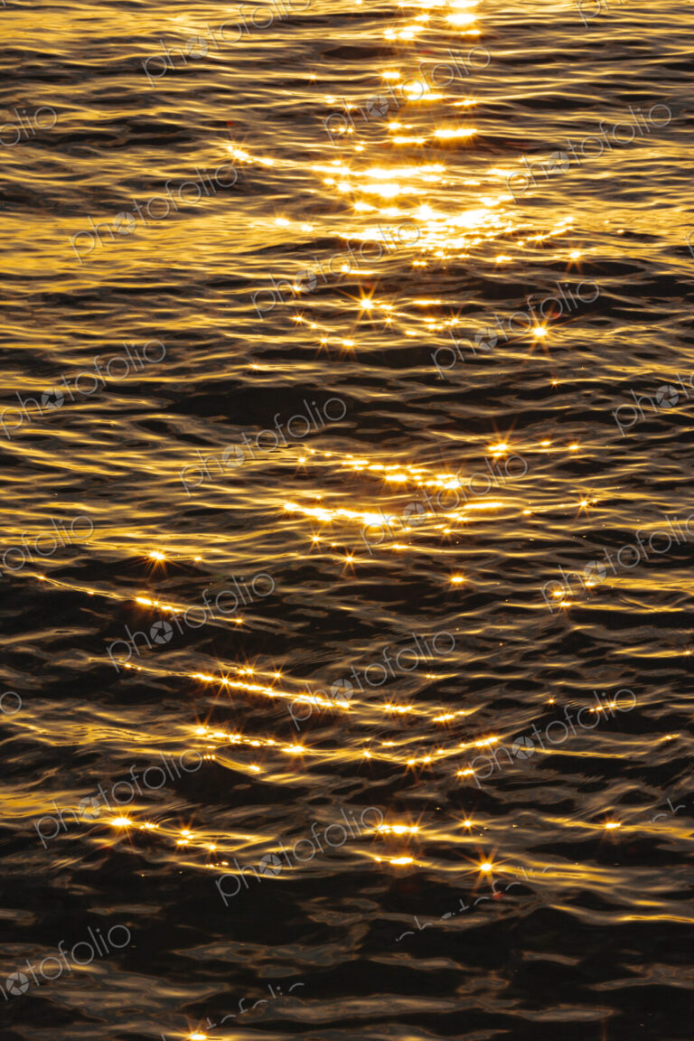 The reflections of sunshine on the surface of moving water.