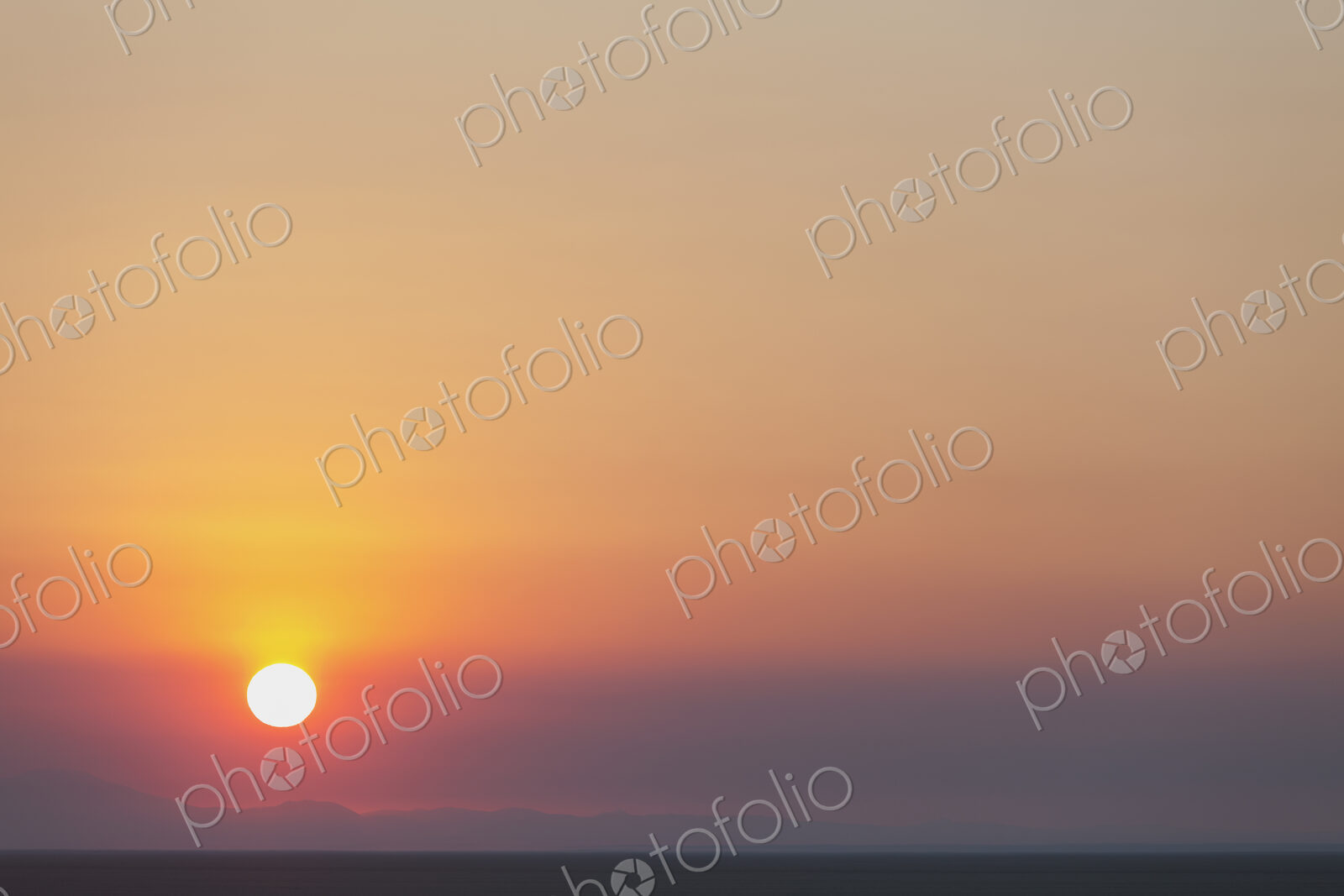 The rising sun over flat desert landscape at dawn in Nevada.