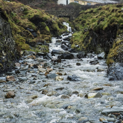 The rocky shore of Pembrokeshire, a bay with a cottage by the water and steps to the… The rocky shore of Pembrokeshire, a bay with a cottage by the water and steps to the…