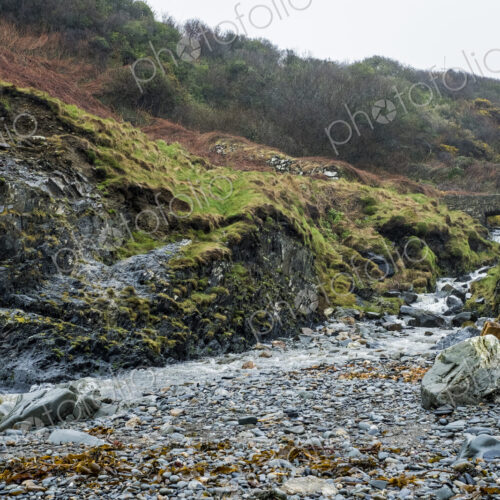 The rocky shore of Pembrokeshire, a bay with a cottage by the water and steps to the… The rocky shore of Pembrokeshire, a bay with a cottage by the water and steps to the…
