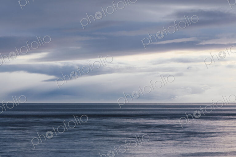 The sea and sky over Puget Sound in Washington, USA. The horizon with light cloud…