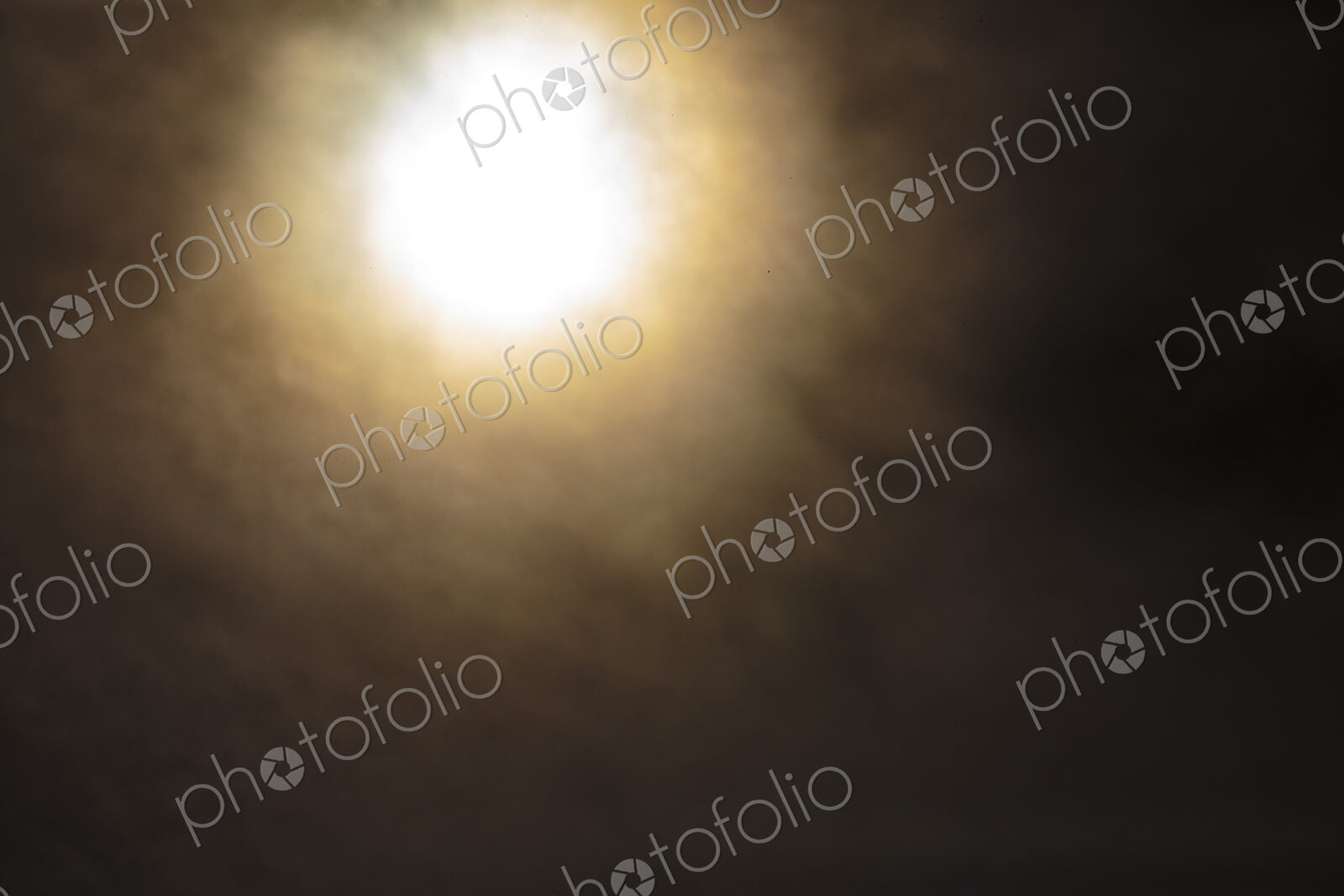 The sun, blurred and behind clouds, USA