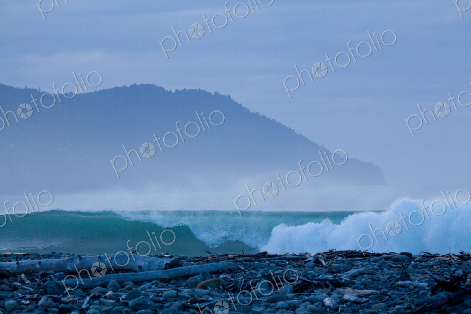 The surf breaking on shore on a beach at the mouth of the River Elwha on Olympic…