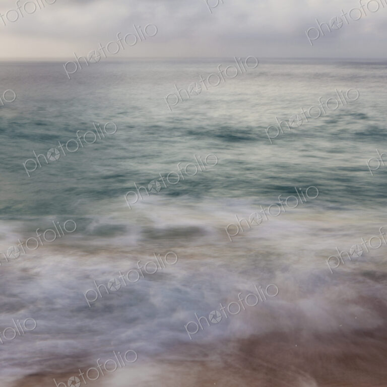 The surface of the ocean and an overcast sky at dawn
