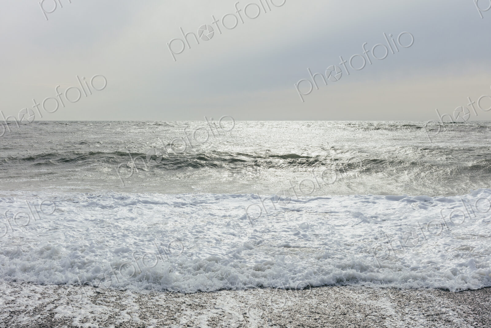 The surface of the ocean and waves, moody overcast sky above