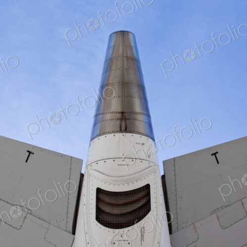 The underside of an aircraft, wings and mesh covered exhaust outlet.